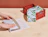 Hands wrapping an item in custom printed white tissue paper beside an open red crate