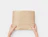 Top-down view of hands holding a item neatly wrapped in brown tissue paper printed with black wavy lines