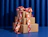 A stack of three kraft cardboard boxes tied with a pink and orange wavy-patterned ribbon bow against a blue background