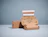 An open brown cardboard phone packaging box branded BackMarket with inner print 'The start of a beautiful friendship.' next to a closed box on a light blue background