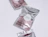 Shiny metallic silver foil ziplock pouches printed with 'Better Health Packed.' and round white sticker labels on a light purple surface