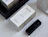 A white pavlok's cosmetics box alongside a black carved lipstick case on a bright surface