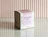 White product box with a botanical print and lilac label on a tiled surface