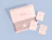 An open light pink magnetic closure box branded 'ÉCLAT JEWELRY' with printed tissue paper, custom cards, and a sticker seal on a blue background