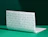 White tissue paper sheet with a repeating green logo pattern, standing on a green surface