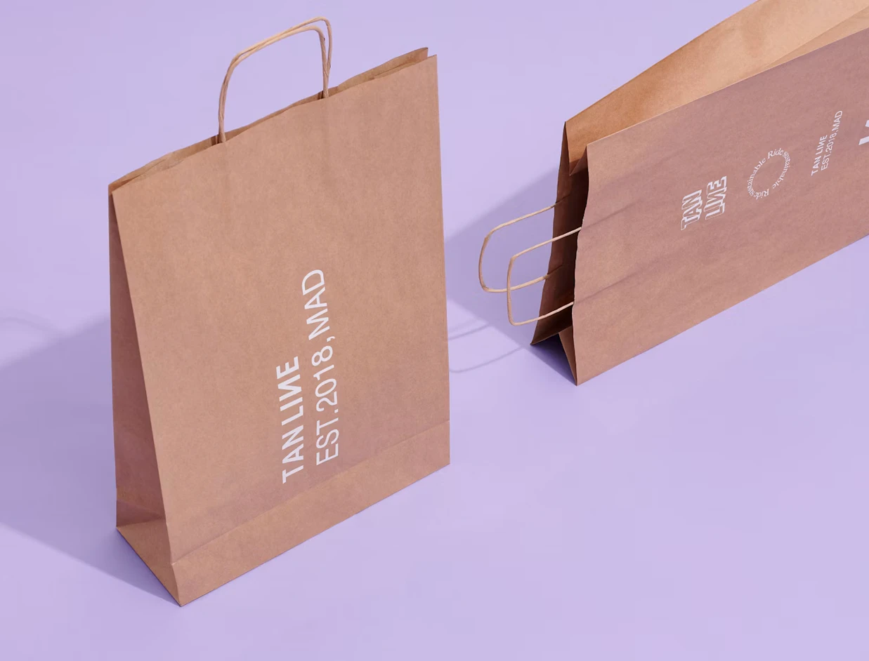Kraft printed paper bags with twisted handles and a white print on a lilac background