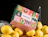 Full colour mailer box with a vivid multicolour festive pattern, resting on lemons