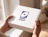 Hands holding a custom white cardboard box printed with a purple 'PIXEL AGENCY' logo