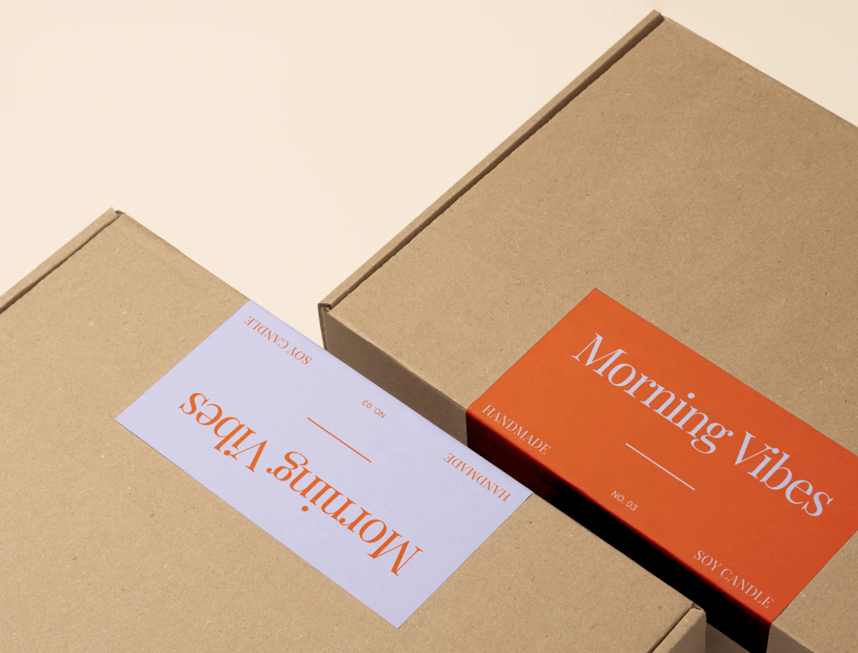 Kraft mailer boxes with rectangular white and orange custom labels on the lids