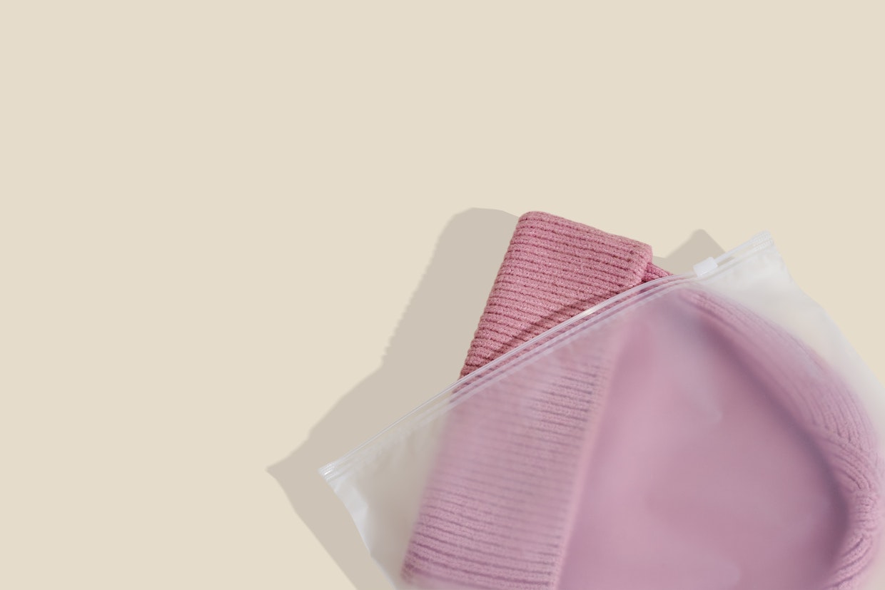 Sachet zippé givré contenant un chapeau rose.