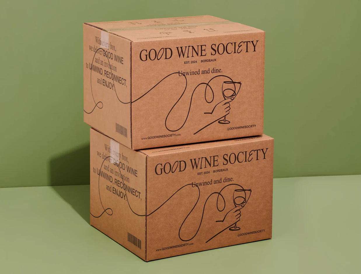 Two stacked kraft shipping boxes with a black line illustration print on a green background