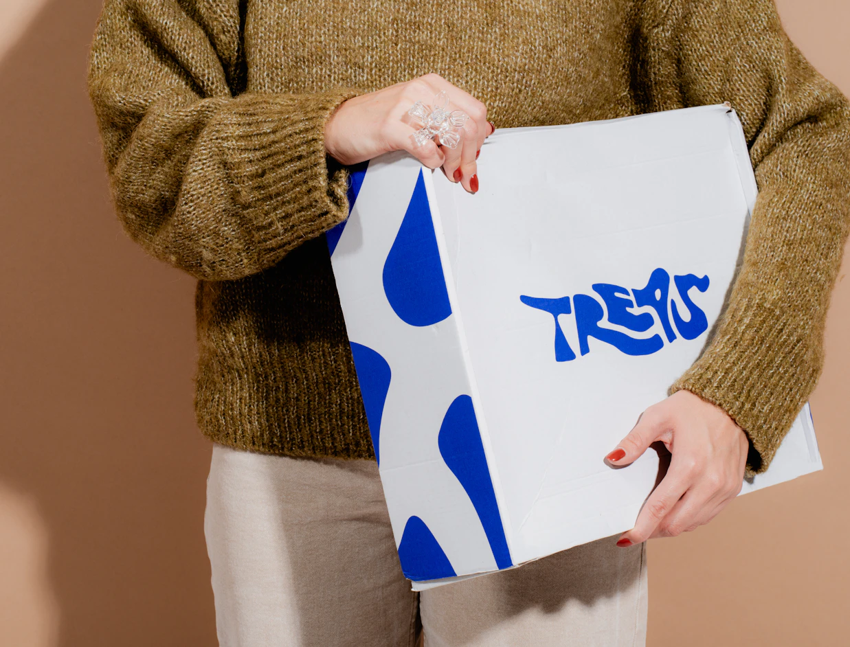 Person holding a white eco colour mailer box with a bold blue print