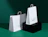 Two white printed paper bags with twisted handles and a green print on a dark green backdrop