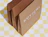 Expandable kraft mailers with a white logo print showing the gusseted sides