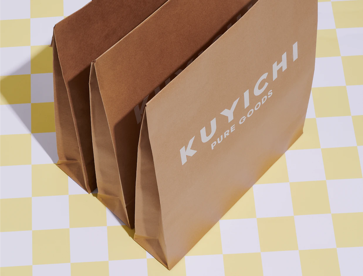 Expandable kraft mailers with a white logo print showing the gusseted sides