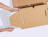 Top-down view of hands placing a laptop into a protective kraft cardboard insert inside a mailer box on a white background