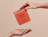 One hand passing an orange square product box labeled 'Midday Boost' to another hand from above