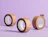 Three rolls of brown paper packaging tape, two with printed wavy lines and one printed with 'FRAGILE', standing upright on a purple background