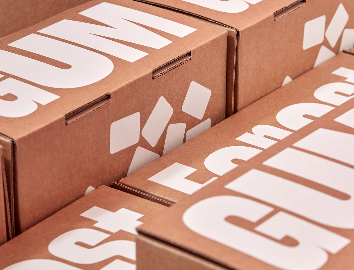 Close-up of stacked kraft mailer boxes with large white lettering and graphic shapes